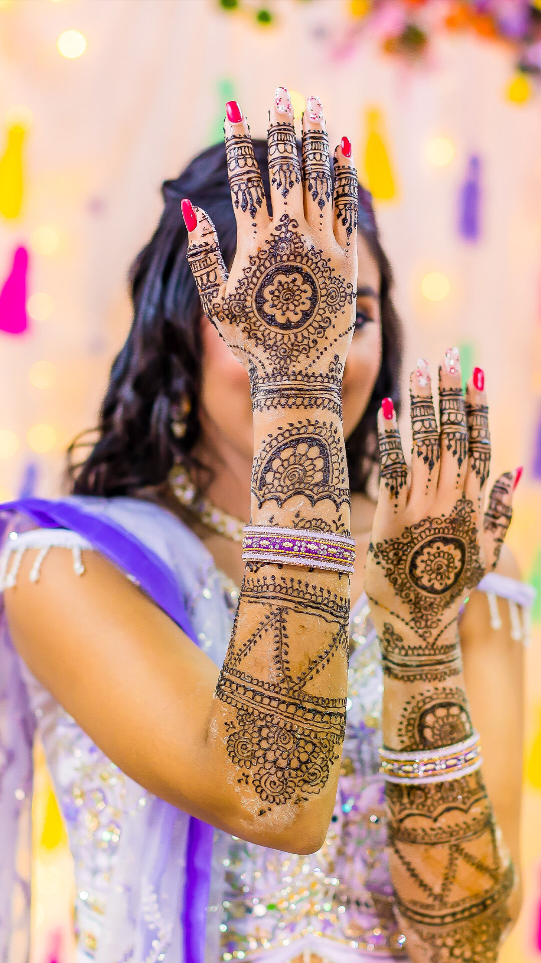 Bride showcasing detailed bridal Mehendi design on hands during wedding festivities